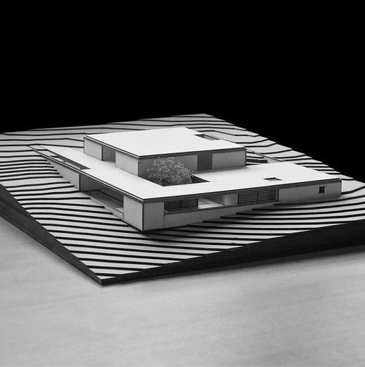 Architectural model showcasing sleek, modern design on terraced landscape.
