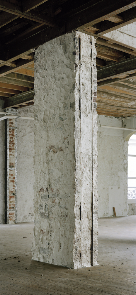 Before: stripped masonry column close-up, exposed brick and plaster layers