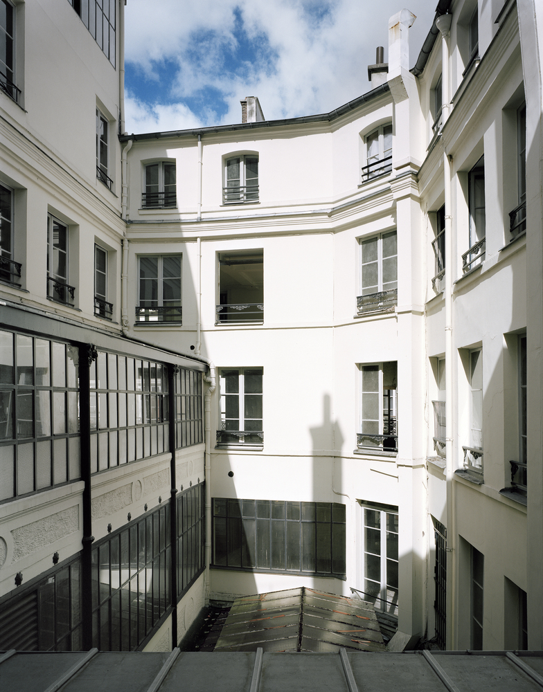 Before: inner courtyard looking up, rendered walls, tall windows