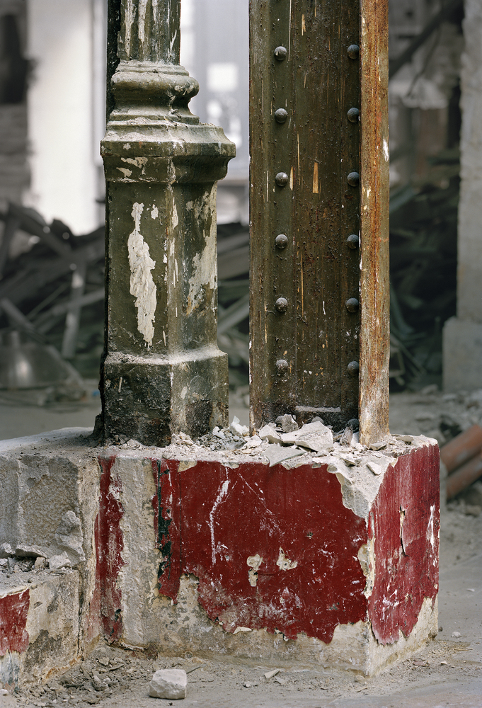 Before: column base close-up, red paint layer, crumbling plaster, stone