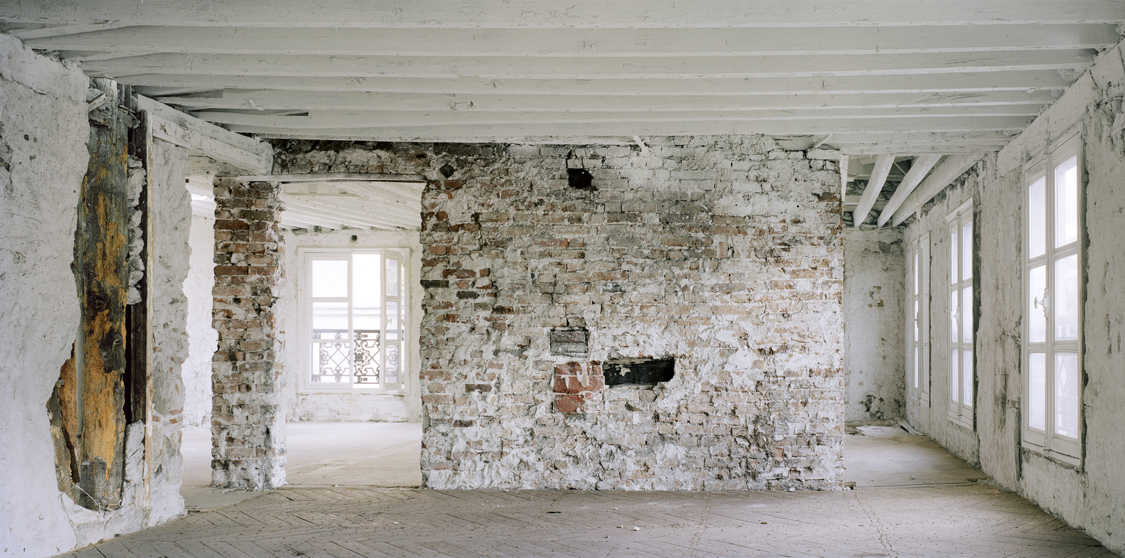 Before: upper floor, thick masonry arches, iron staircase spiral, exposed services