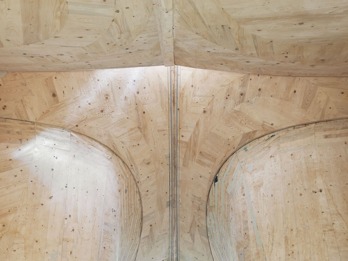 Interior view of laminated plywood ceiling with curved vaulted bays meeting at a central ridge