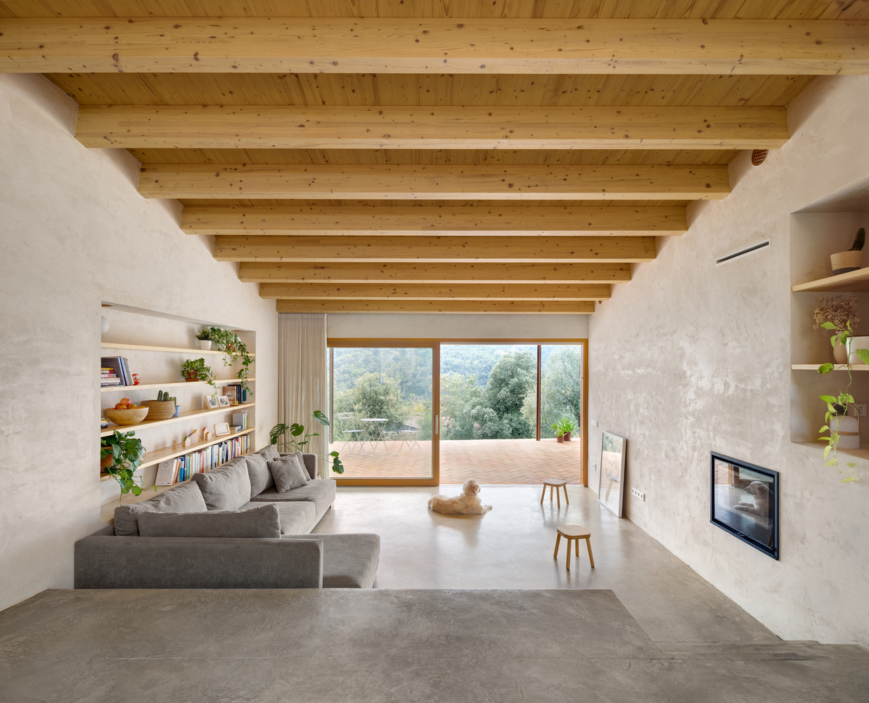 Aerial: the house on its stone terrace, small plunge pool below, olive trees, forest behind