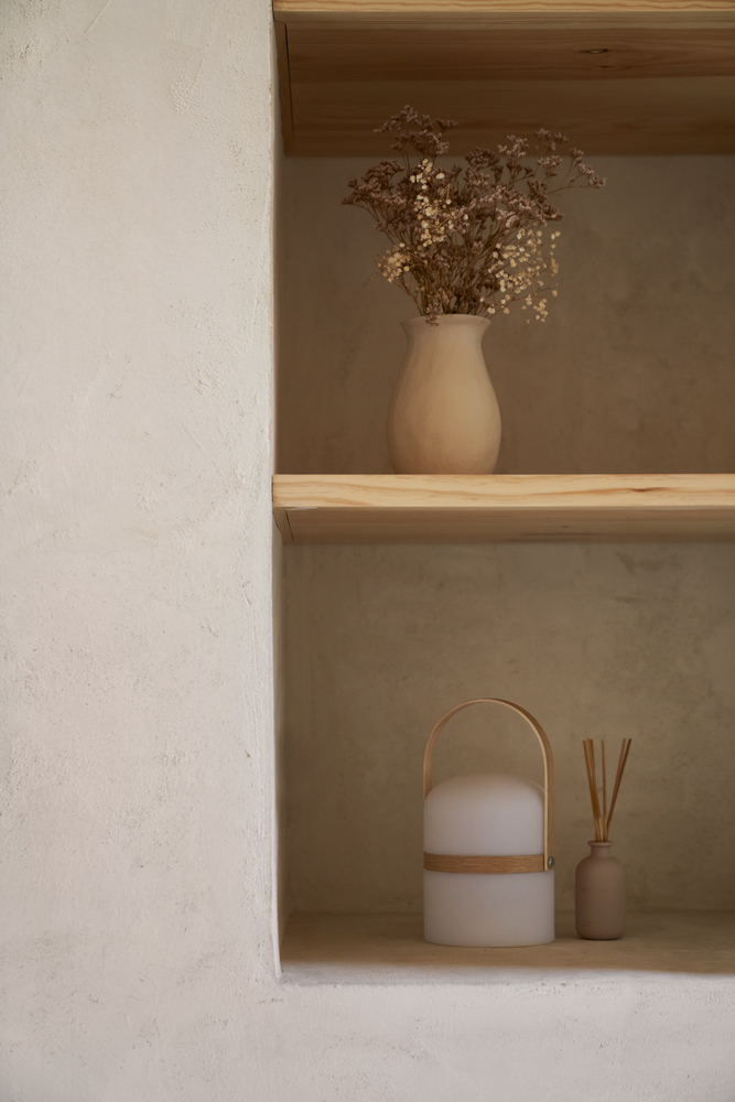 Window detail: small timber-framed window with yellow reveal, white lime render, olive branches