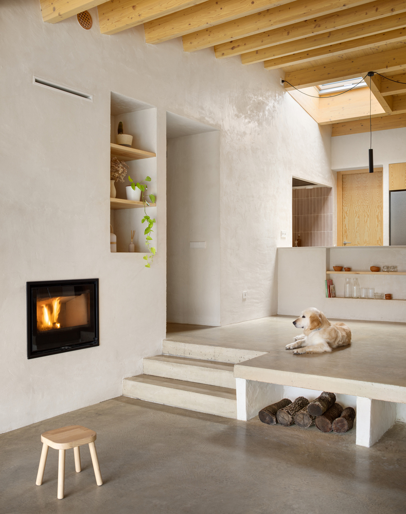 Kitchen detail: curved island end with open shelf, brass tap, black pendant, birch plywood wall