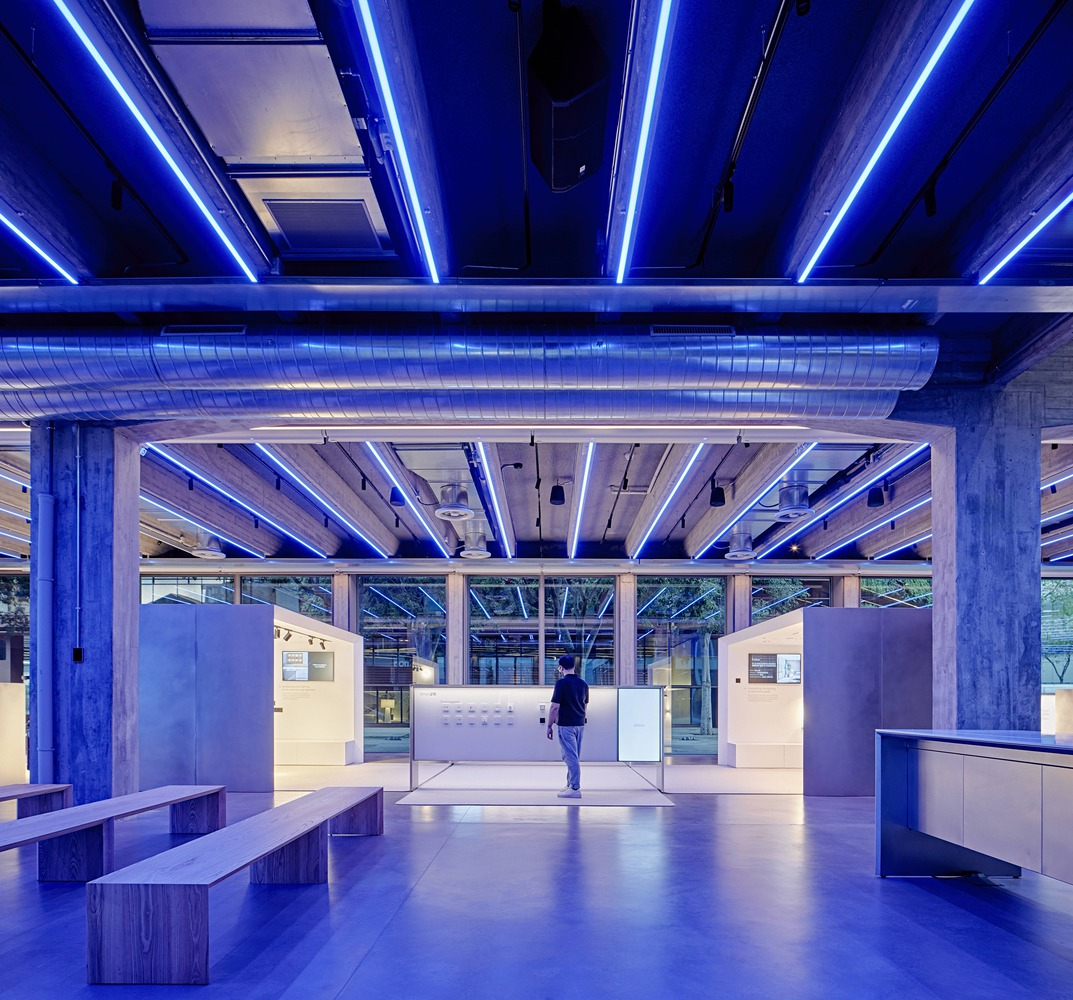 Internal courtyard: steel-framed glass canopy, climbing plants on wires, trees, concrete columns