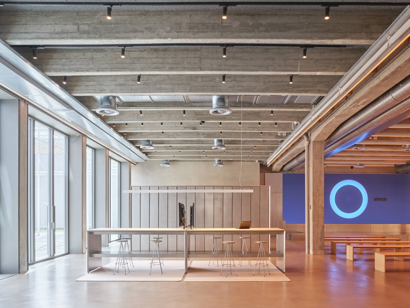 Open workspace corridor: acoustic ceiling panels, full-height glazing with louvres, privacy pods along the facade