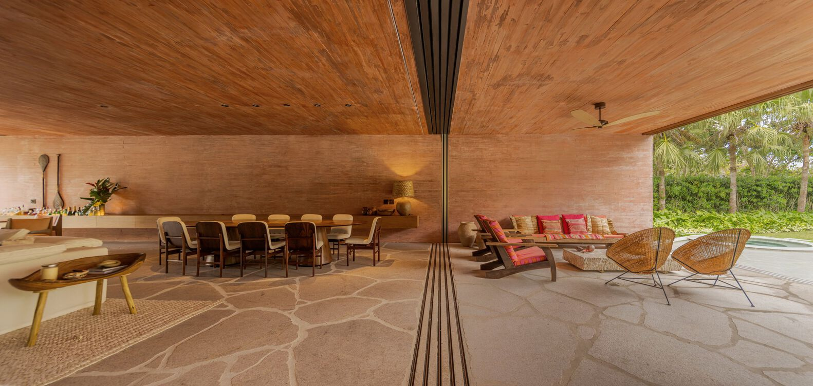 Living and dining area with vaulted timber ceiling and central metal column under afternoon light