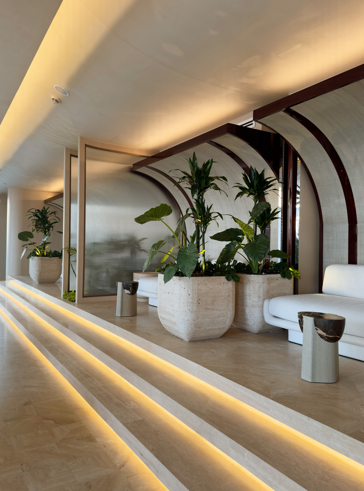 Ilios stepped lounge: arched forms framing white sofas, tropical plants in stone planters, LED step lights