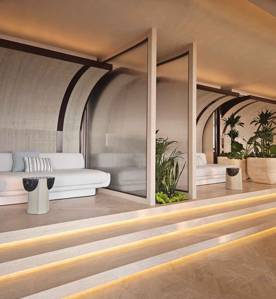 Nalu stepped terrace: arched concrete canopy, white sofas on platforms, plants, ocean-facing