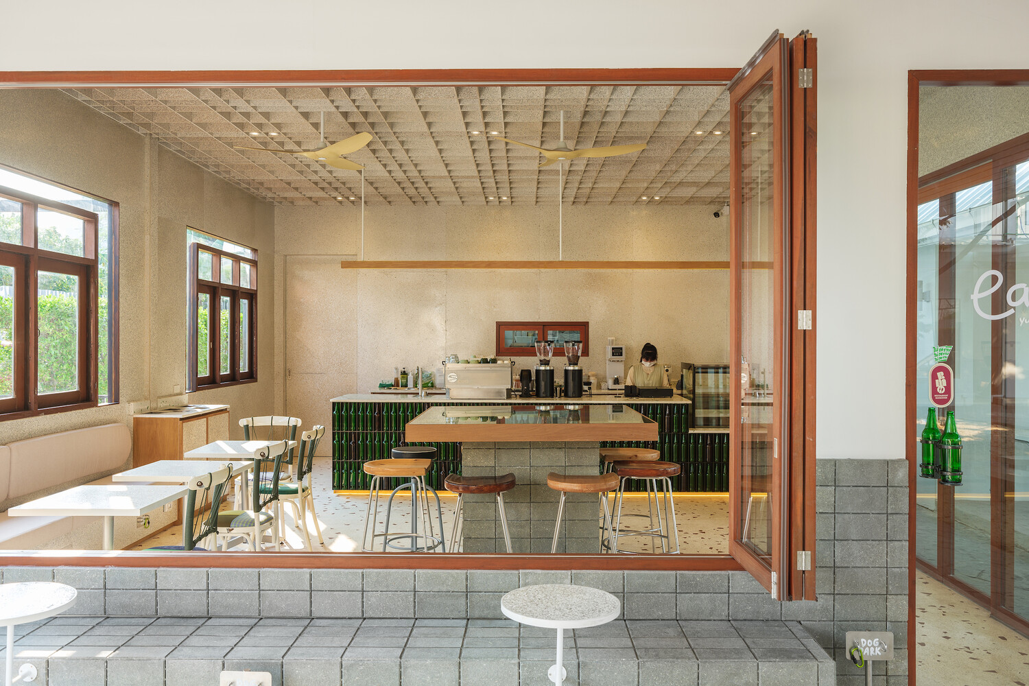 Through the folding doors: interior seen from the covered terrace, concrete block base, terrazzo tiles