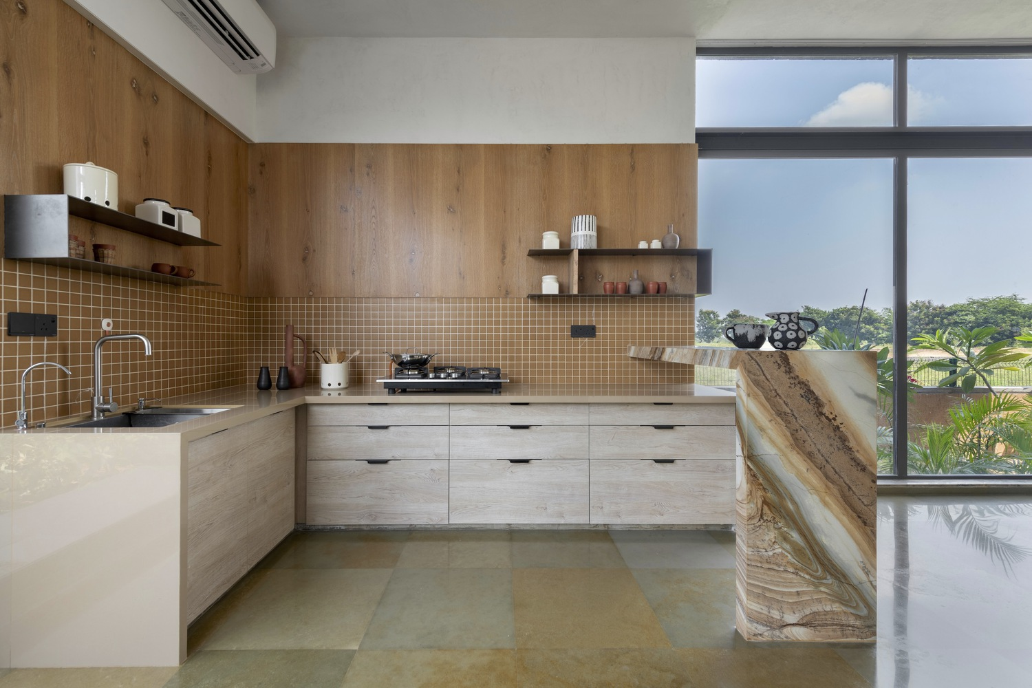 Kitchen: oak veneer cabinets, brown mosaic tile backsplash, concrete and stone island, open shelving, full-height window to the garden