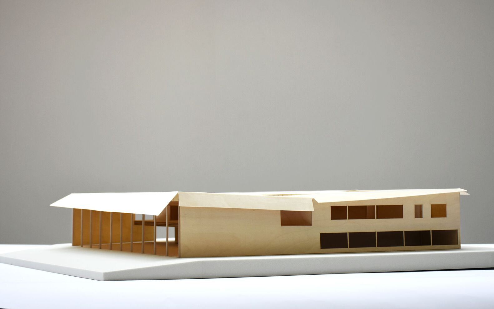 Physical model showing the angled roof and timber column rhythm on a white plinth