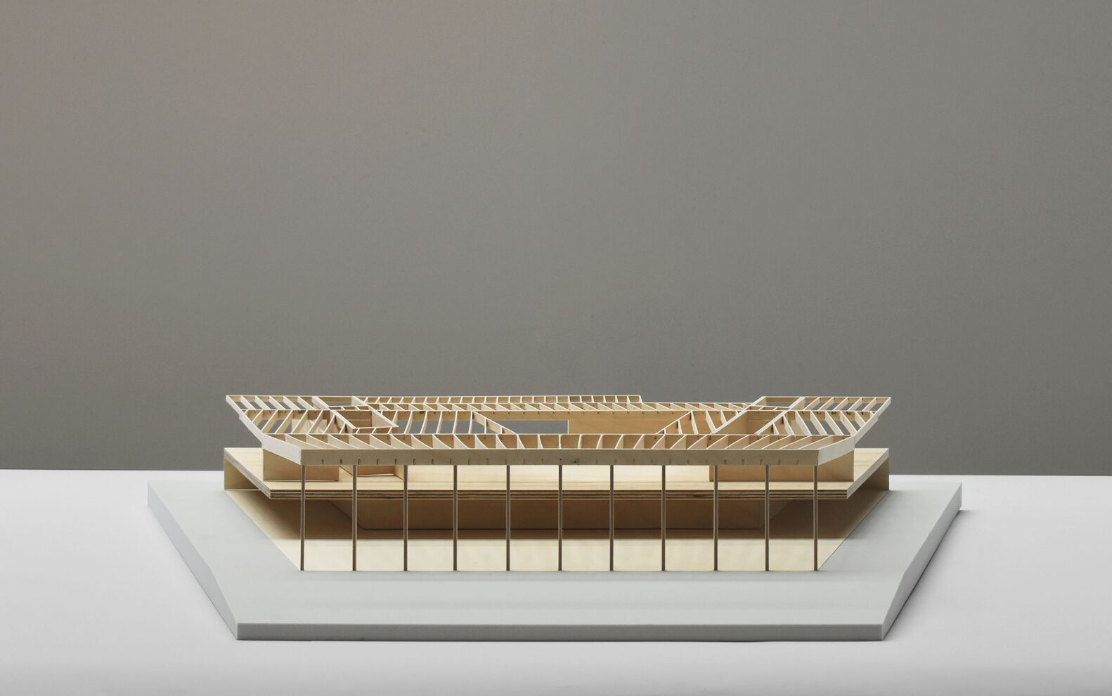 Physical model showing the exposed timber roof structure and glazed facade in neutral light