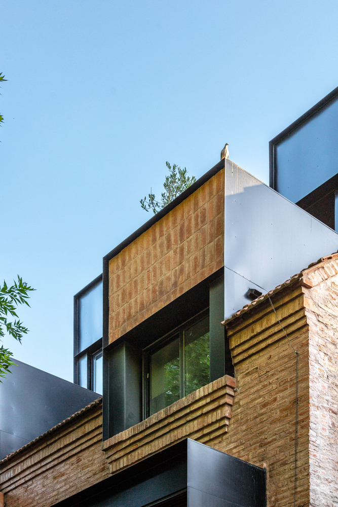 Facade composition with terracotta tile panel and horizontal timber louvre screen flanked by white rendered walls