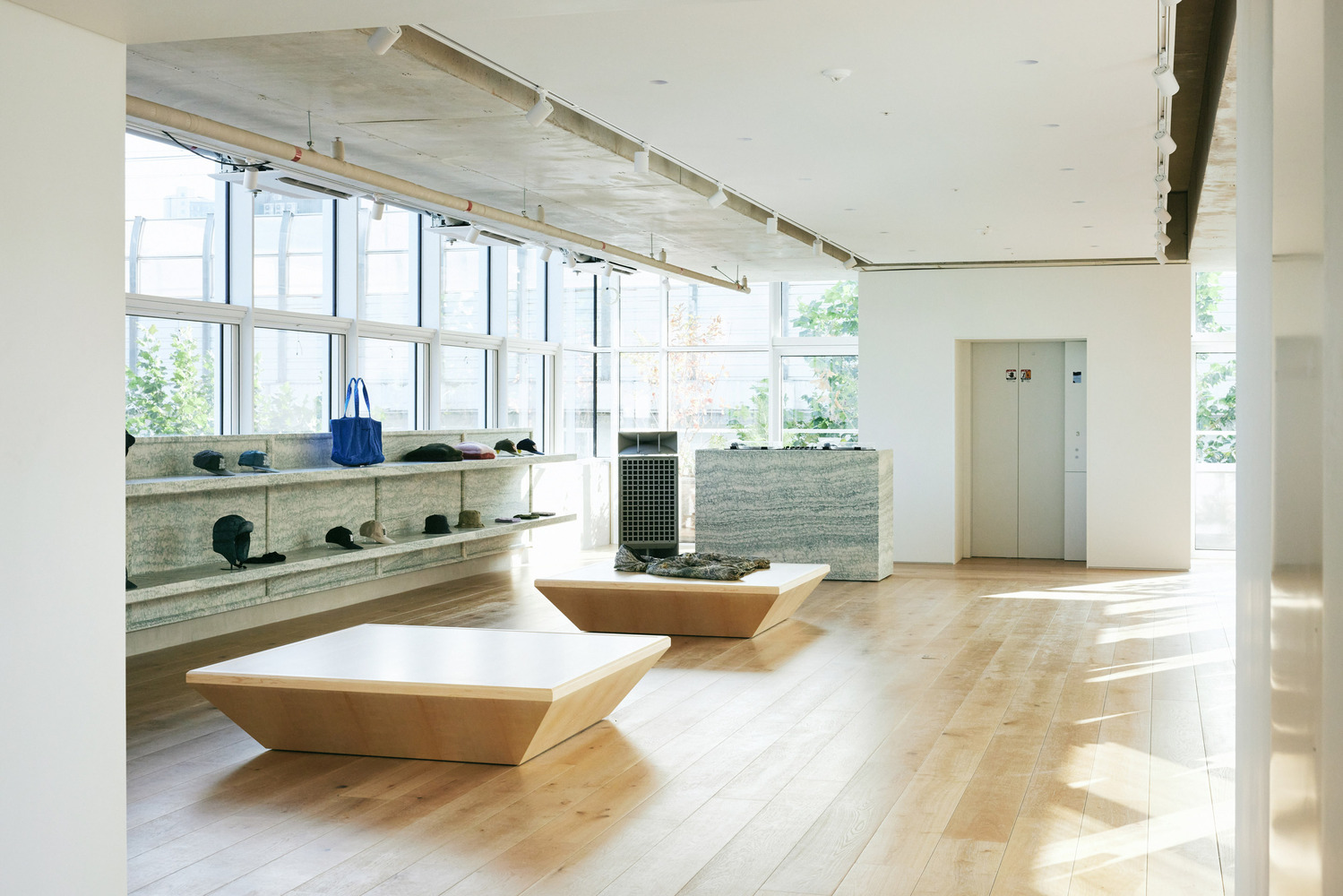 Accessories corner: granite counter and stone display niche, plywood table with folded garment, hanging rail visible through opening