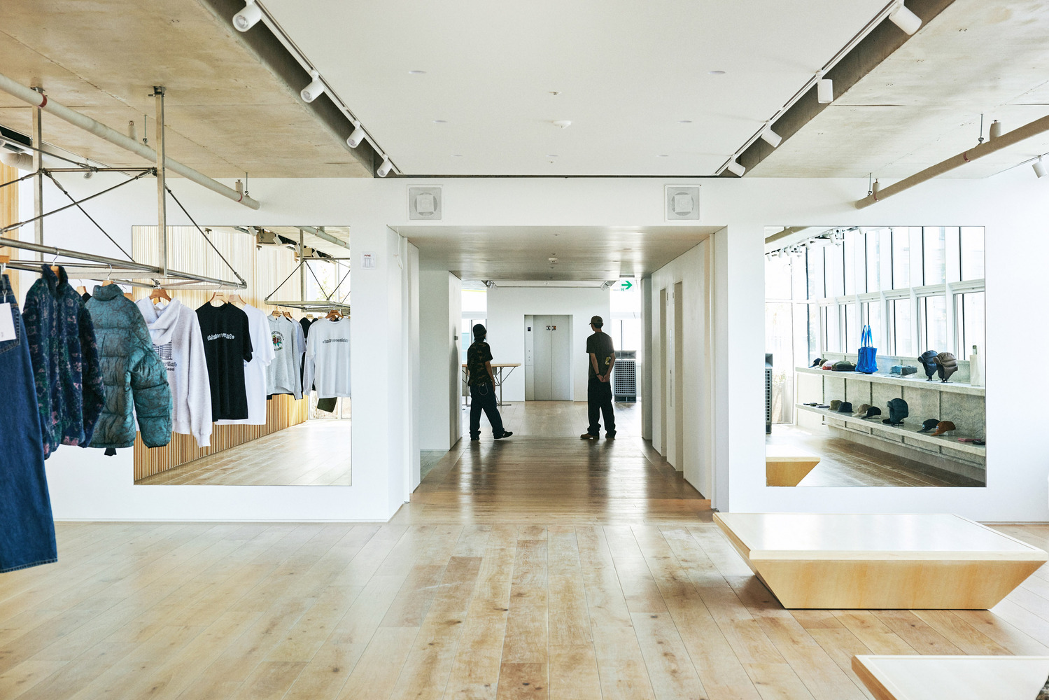 Central corridor: white partition walls with mirror-like openings into display rooms, concrete ceiling, oak floor, figures shopping
