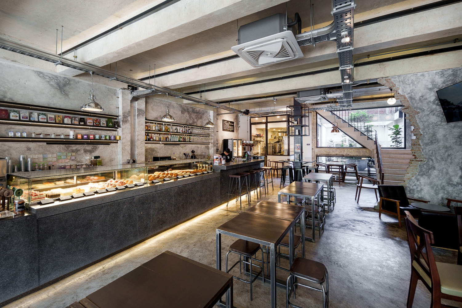 Light well: removed rear balcony revealing exposed brick, concrete beams, potted tree, glass door to interior