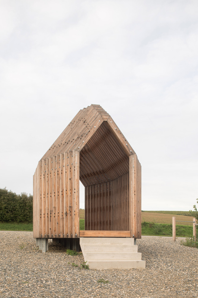 Front elevation showing concrete stairs leading to open gabled entrance with vertical timber slat cladding