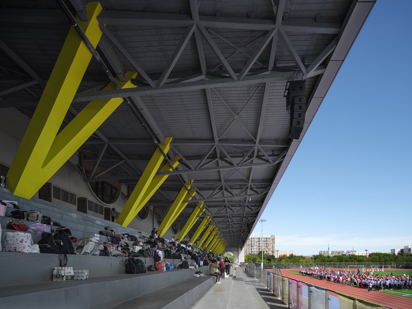 Facade detail: concentric circular relief sculpture in concrete panel, large circular window, sports centre beyond