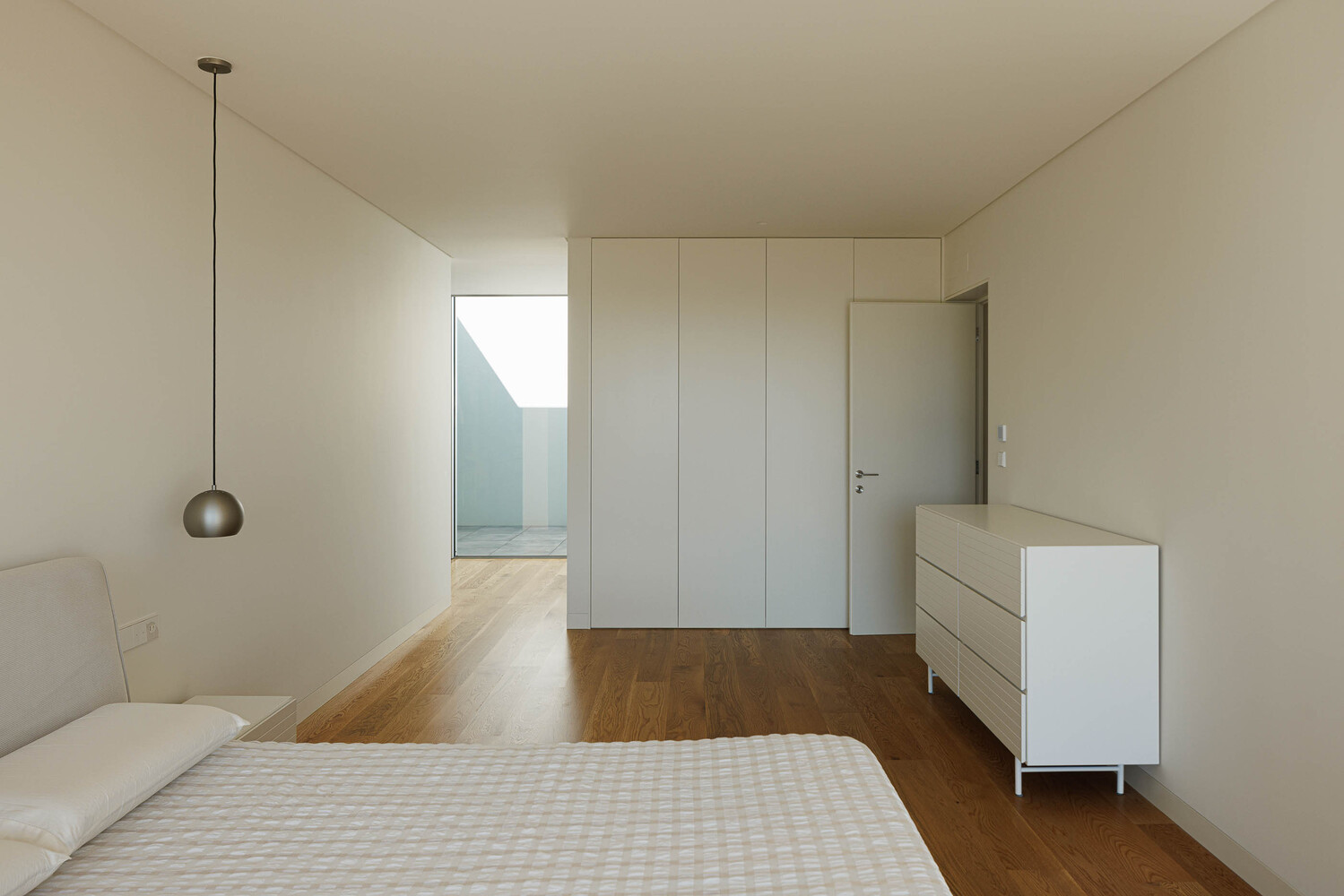 Bedroom with built-in wardrobes and pendant light overlooking an adjacent space with skylight