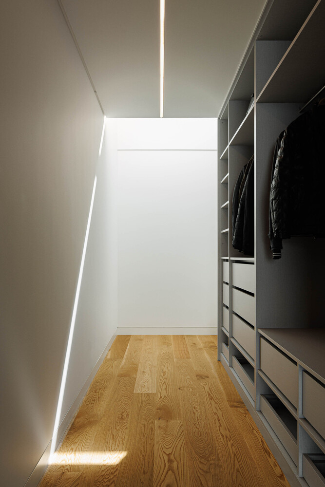Walk-in closet with continuous LED strip lighting along wall and ceiling joint