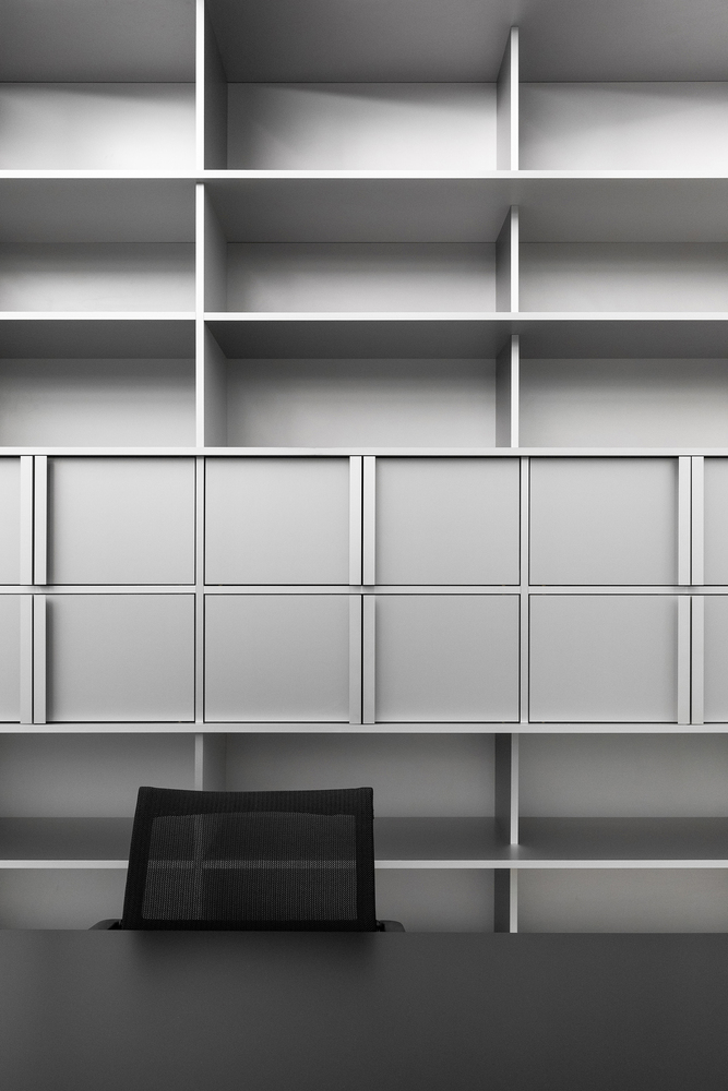 Detail: grey shelving compartments with black laptop holder, grid pattern