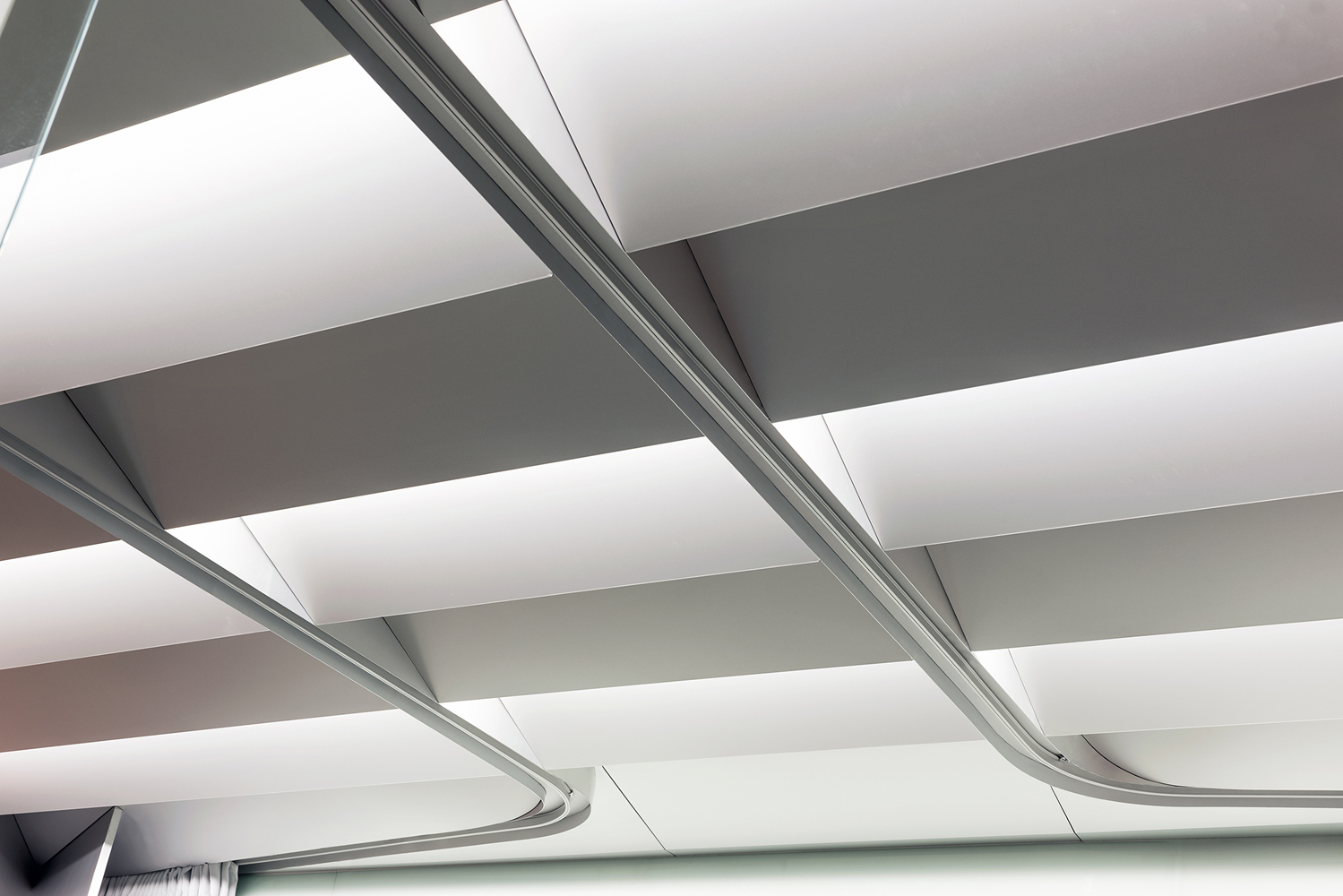 Ceiling detail: white acoustic baffles, aluminium conduit running between them