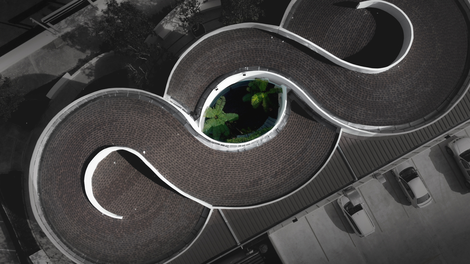 Aerial view of the curved roof with three lobed forms enclosing a central planted courtyard