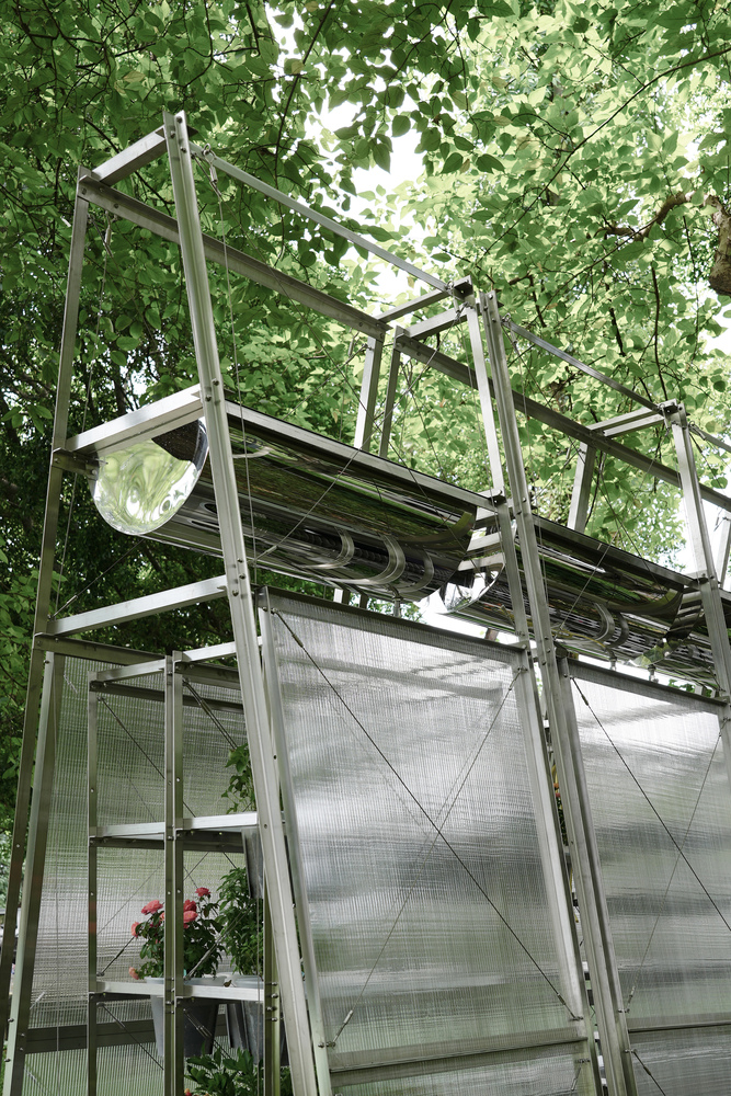 Upward view of the raised water collection gutter framed by green canopy overhead