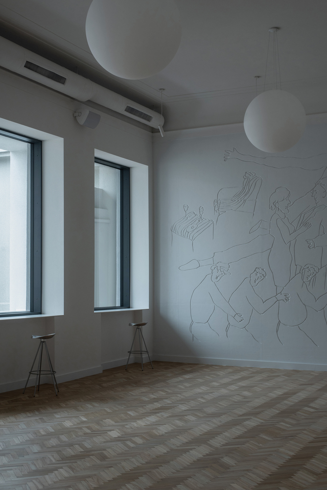 Interior room with parquet floor, figurative wall drawing, spherical pendant lights and two deep-set windows