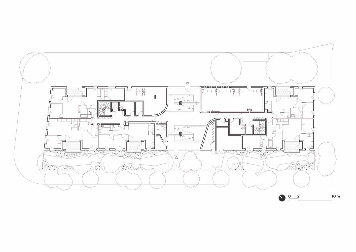 Floor plan drawing depicting residential units with outdoor terraces and landscaped perimeter with trees