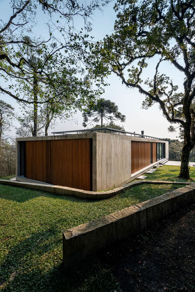 Corner facade with alternating timber and board-formed concrete panels on raised concrete plinth