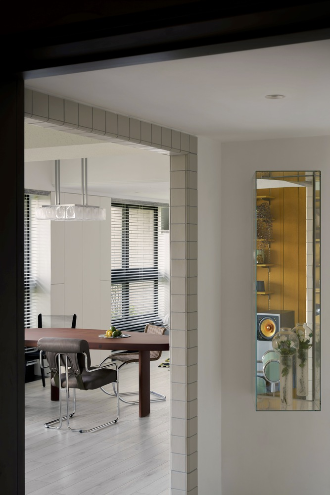 View through tiled doorway into dining area with venetian blinds filtering daylight