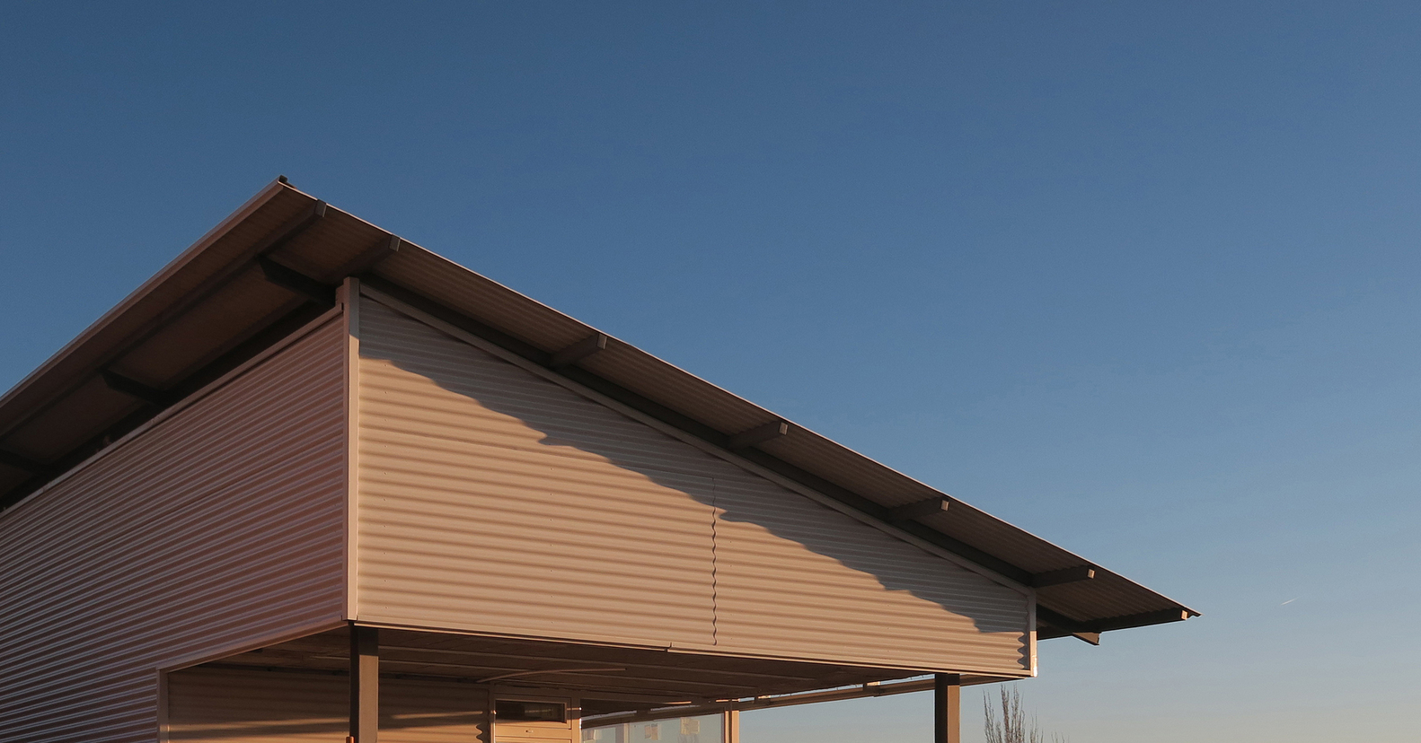 Angled view of the gabled roof overhang with exposed rafters at dusk