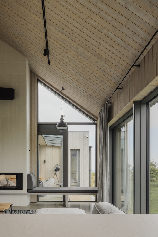 Triangular window opening framing a view to an adjacent timber-clad volume across the courtyard