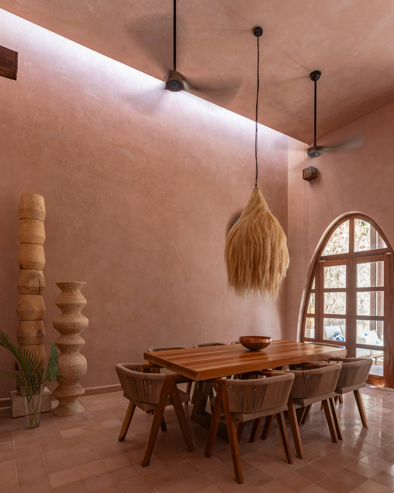 Dining room with terracotta tile floor and clerestory lighting beneath a pink vaulted ceiling