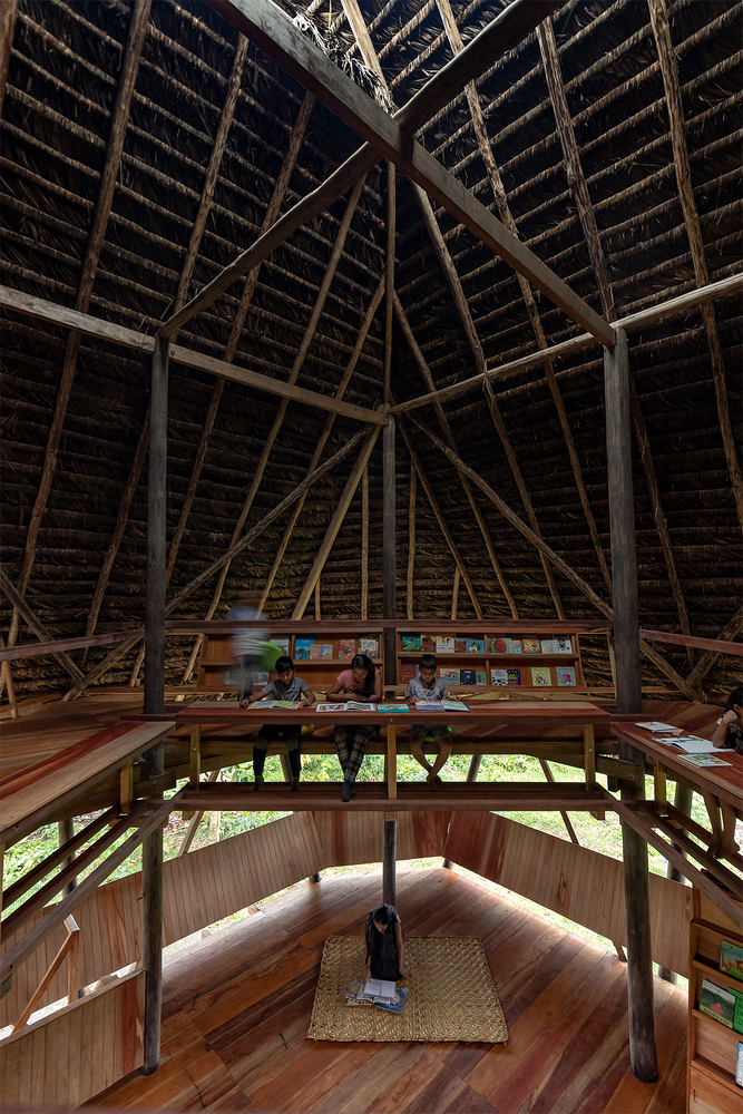 Vertical view through three stacked timber floor platforms with children reading on upper and lower levels