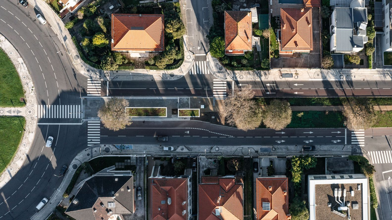 Aerial view of a dark linear structure spanning a street intersection with pedestrian crossings