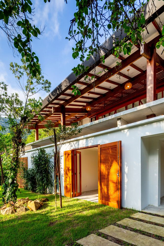 Entry level with timber pergola, louvered shutters, and stepped stone pathway through planted lawn