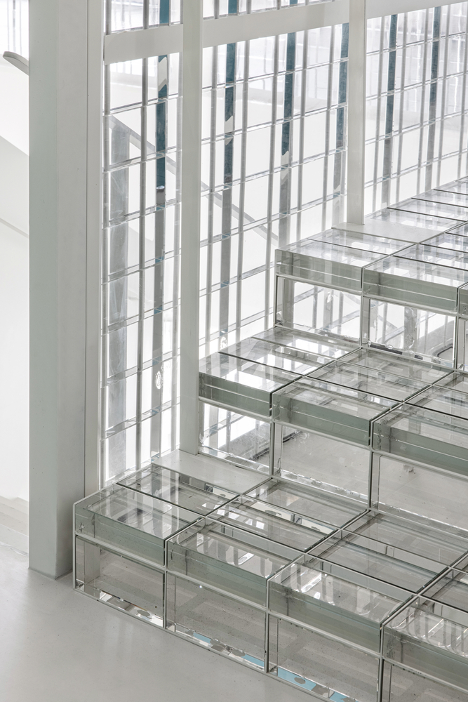 Detail of glass block stair treads meeting a vertical translucent screen wall
