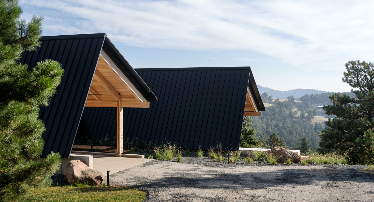Covered carport and entry with timber structure connecting the two gabled volumes