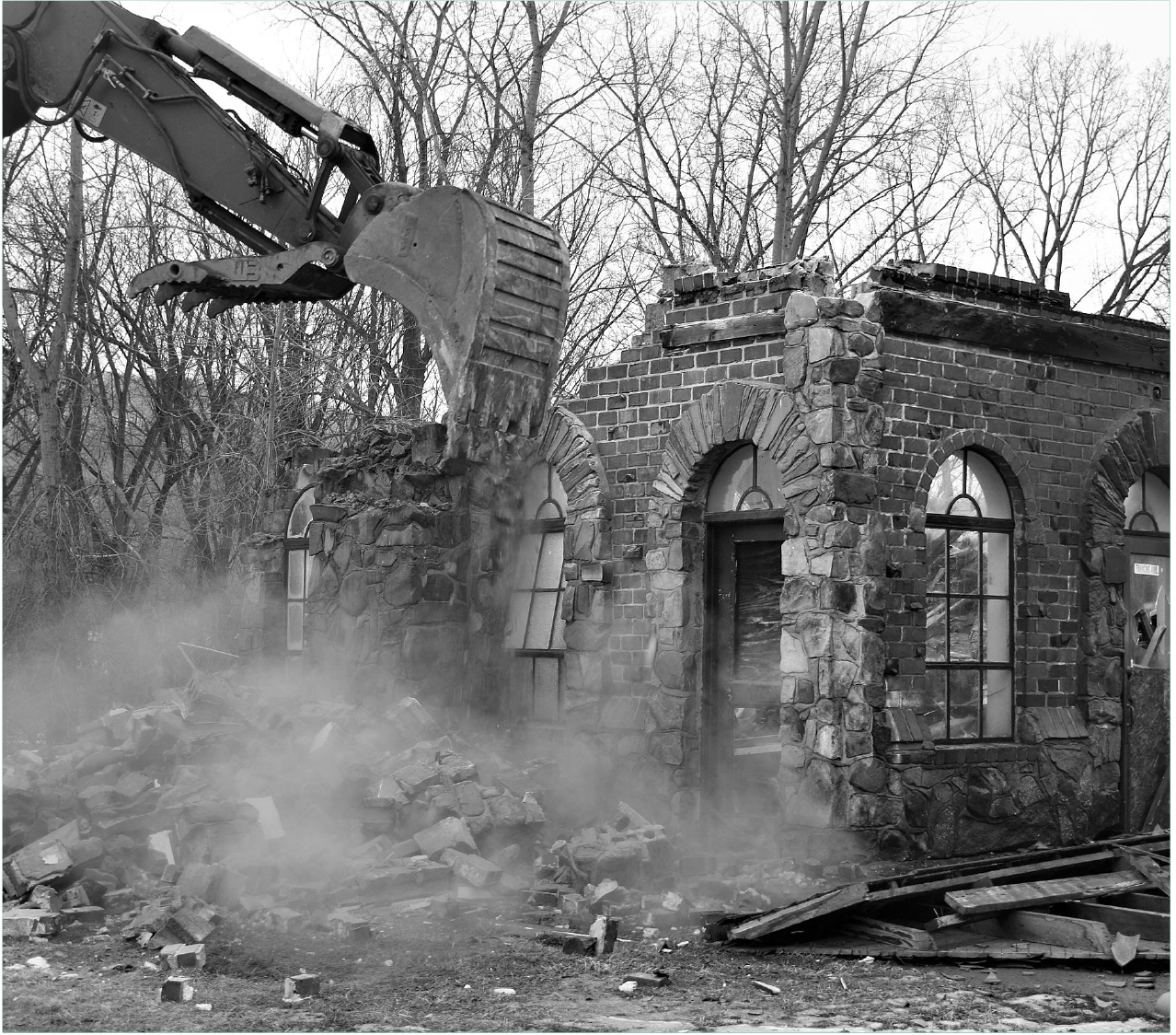 Machinery at work dismantling a stone building, marking the transition from the old to the new.