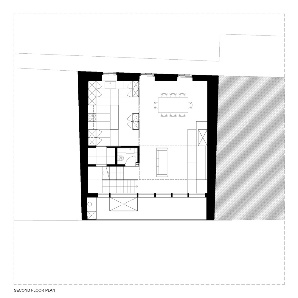 Second floor plan drawing showing kitchen, dining area and central circulation with stairwell descending below