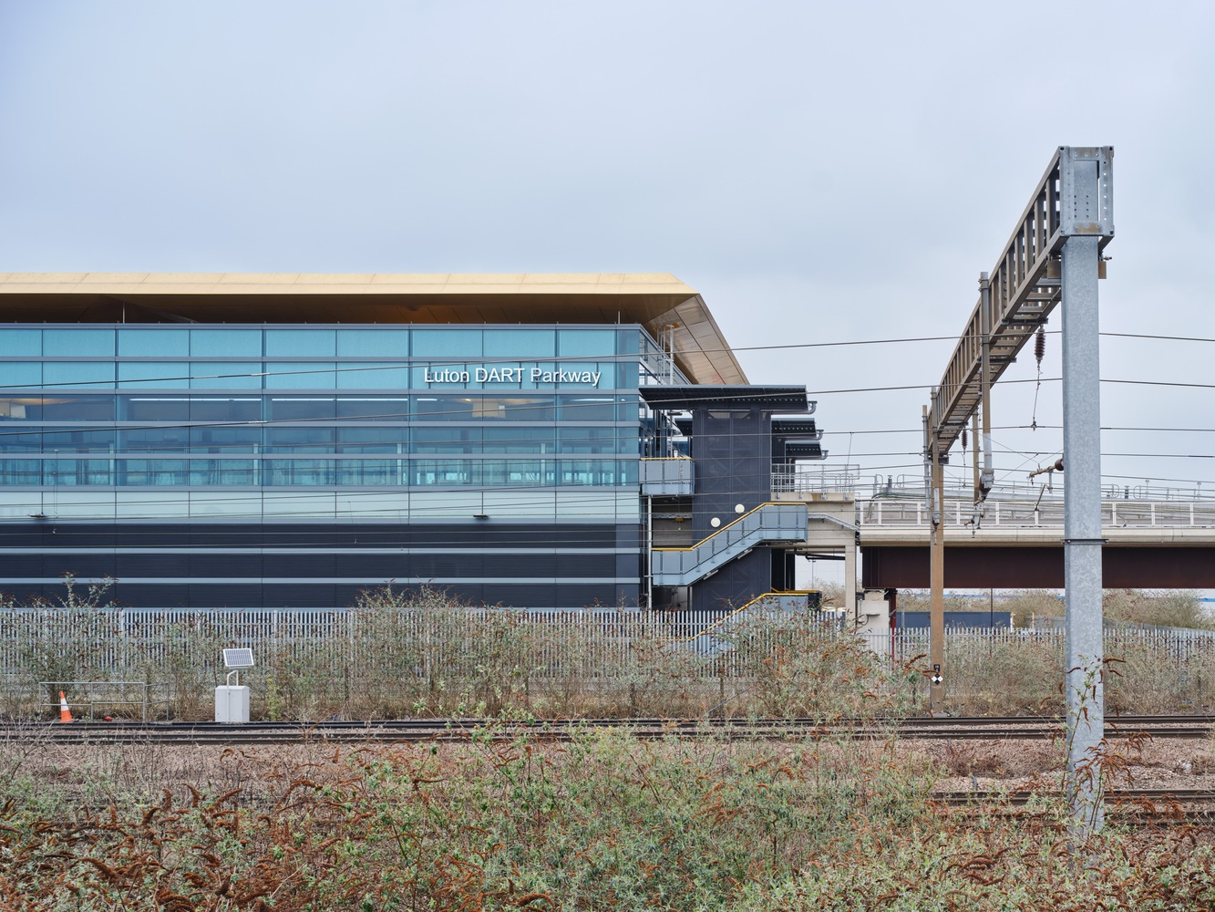 Station building with flat canopy seen across railway tracks and bare winter vegetation
