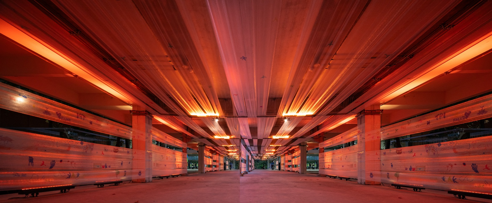 Symmetrical view down the platform showing timber slat walls illuminated by red and amber strip lighting