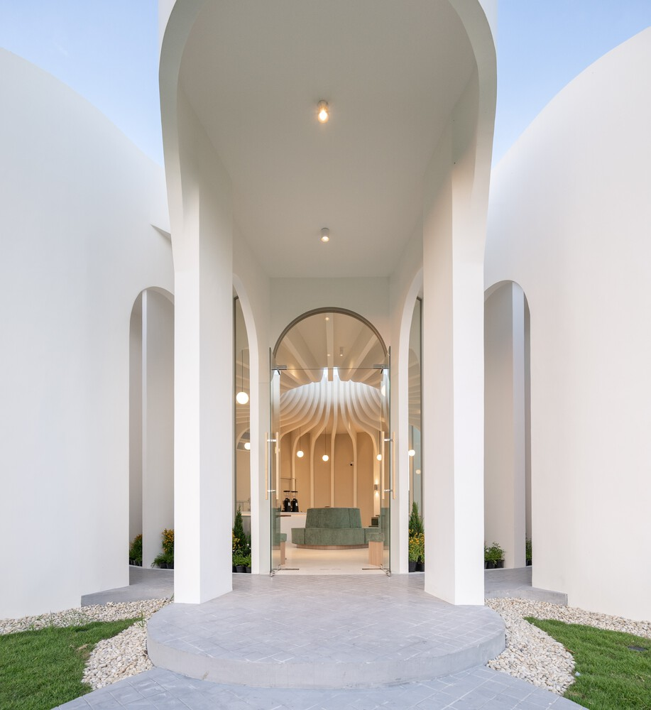 Entry portal framed by arched columns with view through to the sculpted interior ceiling