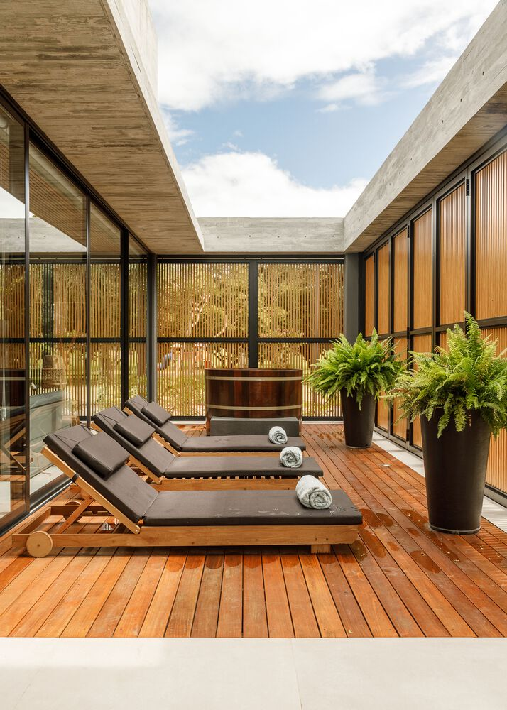 Interior courtyard with timber decking, loungers, and vertical timber screens under open sky