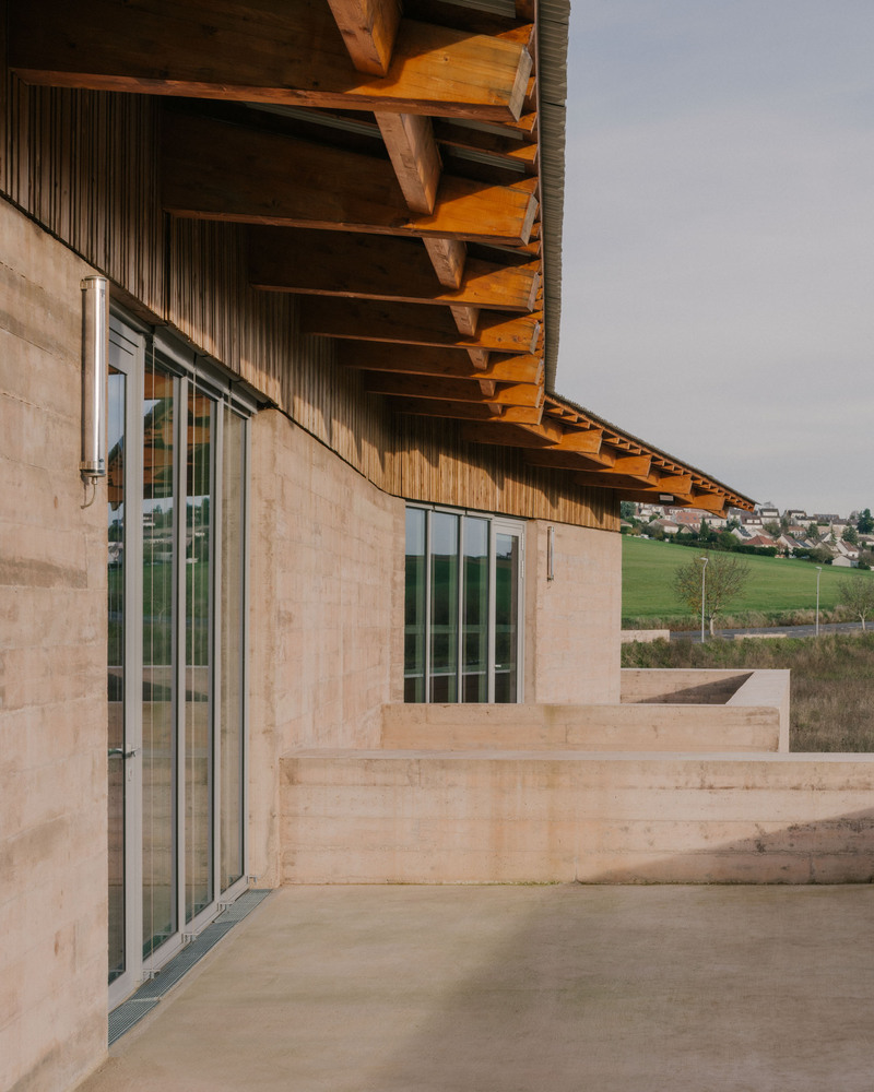 Corner terrace with concrete floor and timber roof soffit overlooking rolling hills and village in distance