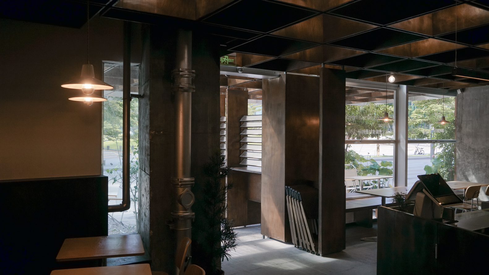 Interior view at dusk showing exposed ductwork, steel columns, and warm lighting through the coffered ceiling